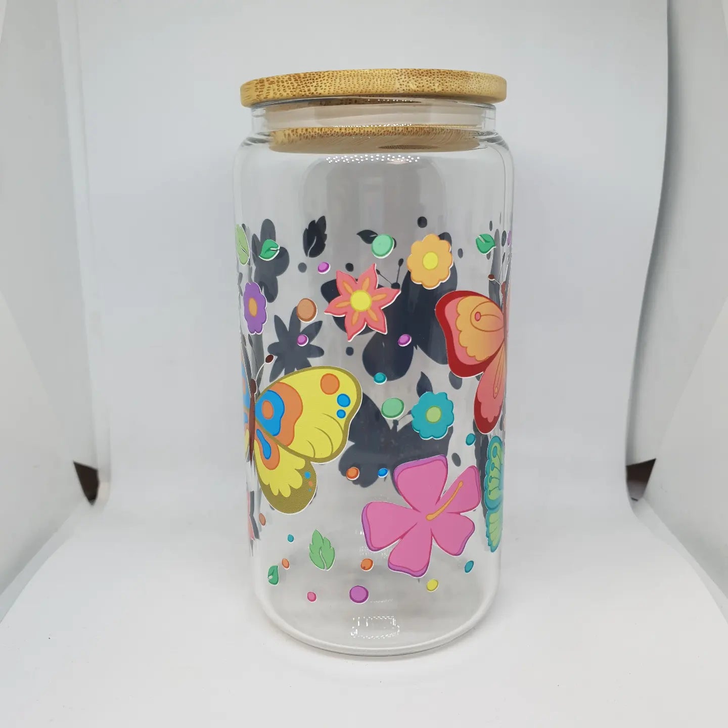 Clear glass jar with colorful butterfly designs and a wooden lid