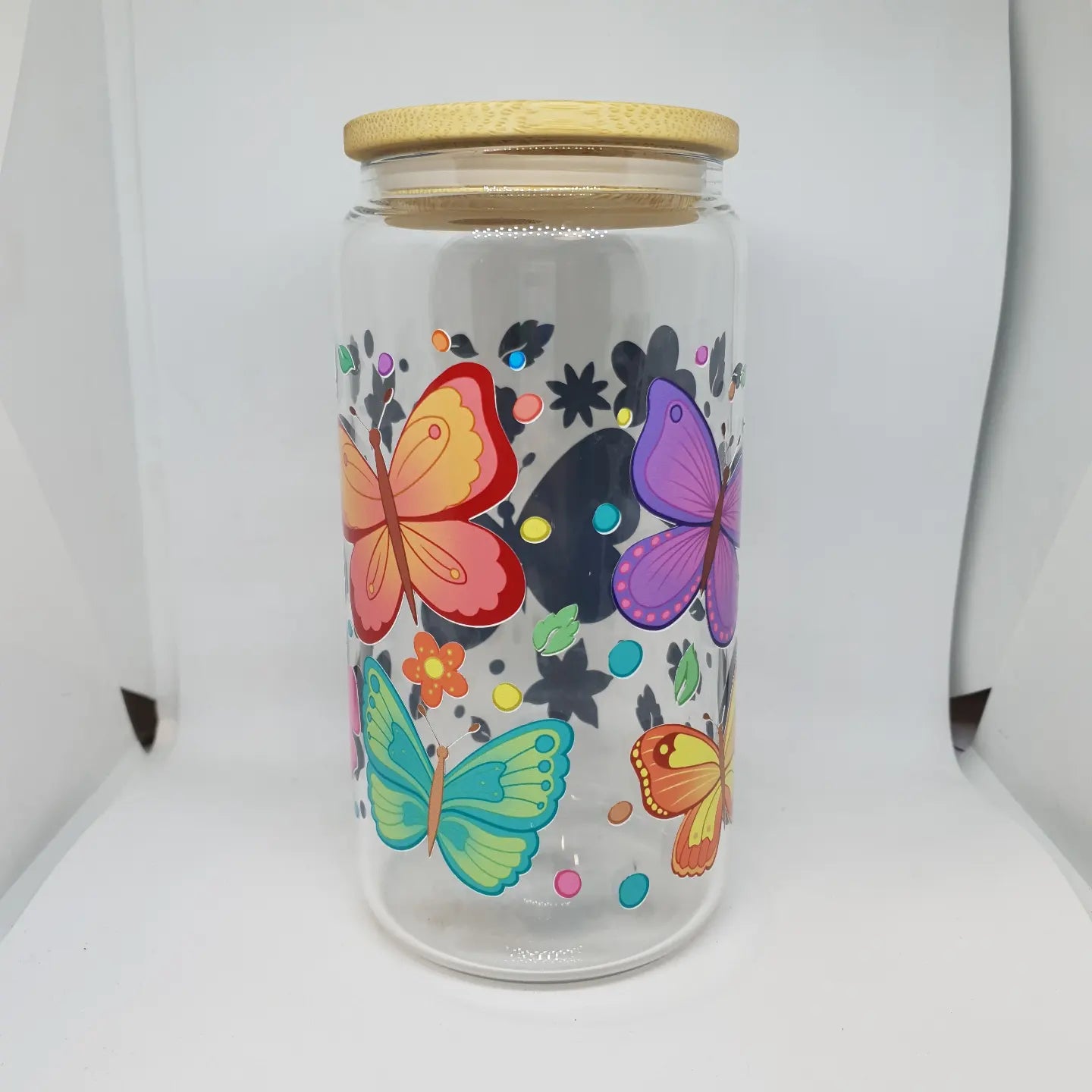 Glass jar with wooden lid featuring colorful butterfly designs