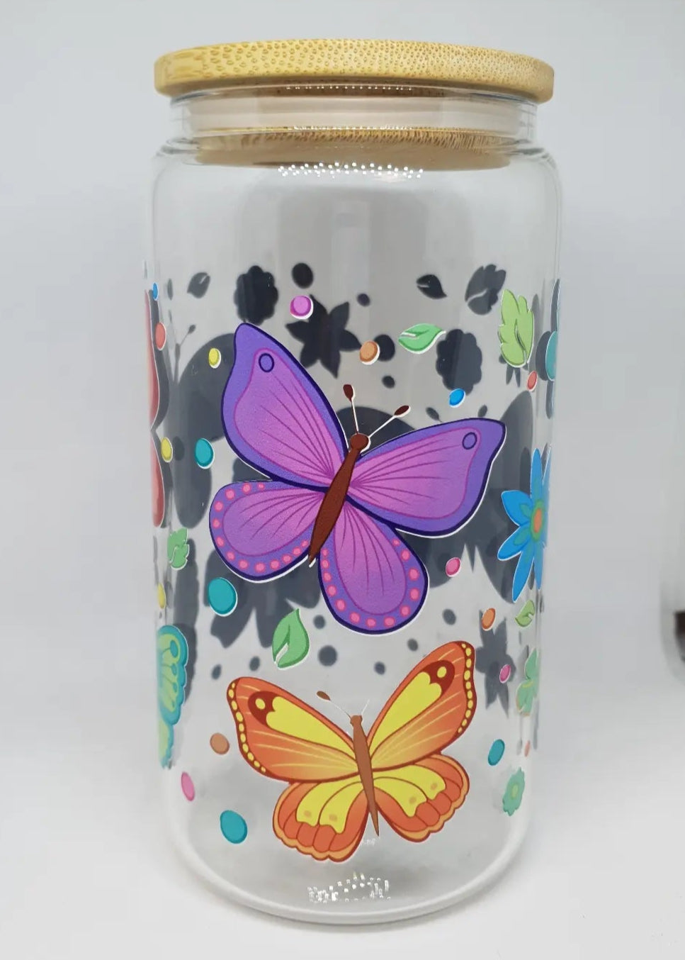Glass jar with butterfly designs and a wooden lid