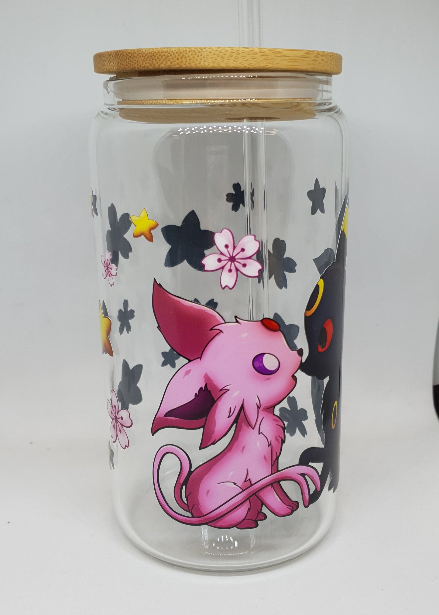 Clear glass tumbler with pink cartoon character and floral designs on a white background
