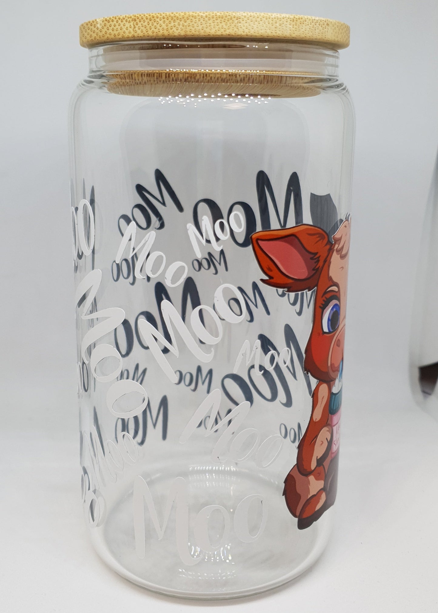 Glass jar with decorative lid featuring artistic design and text on a white background