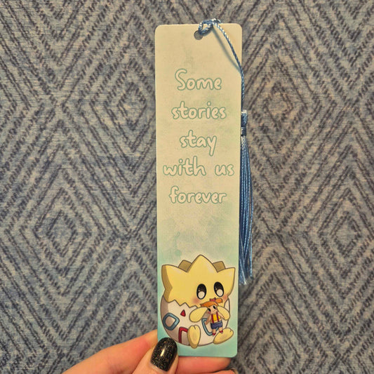 Bookmark with cartoon character and text held by a hand against a patterned background