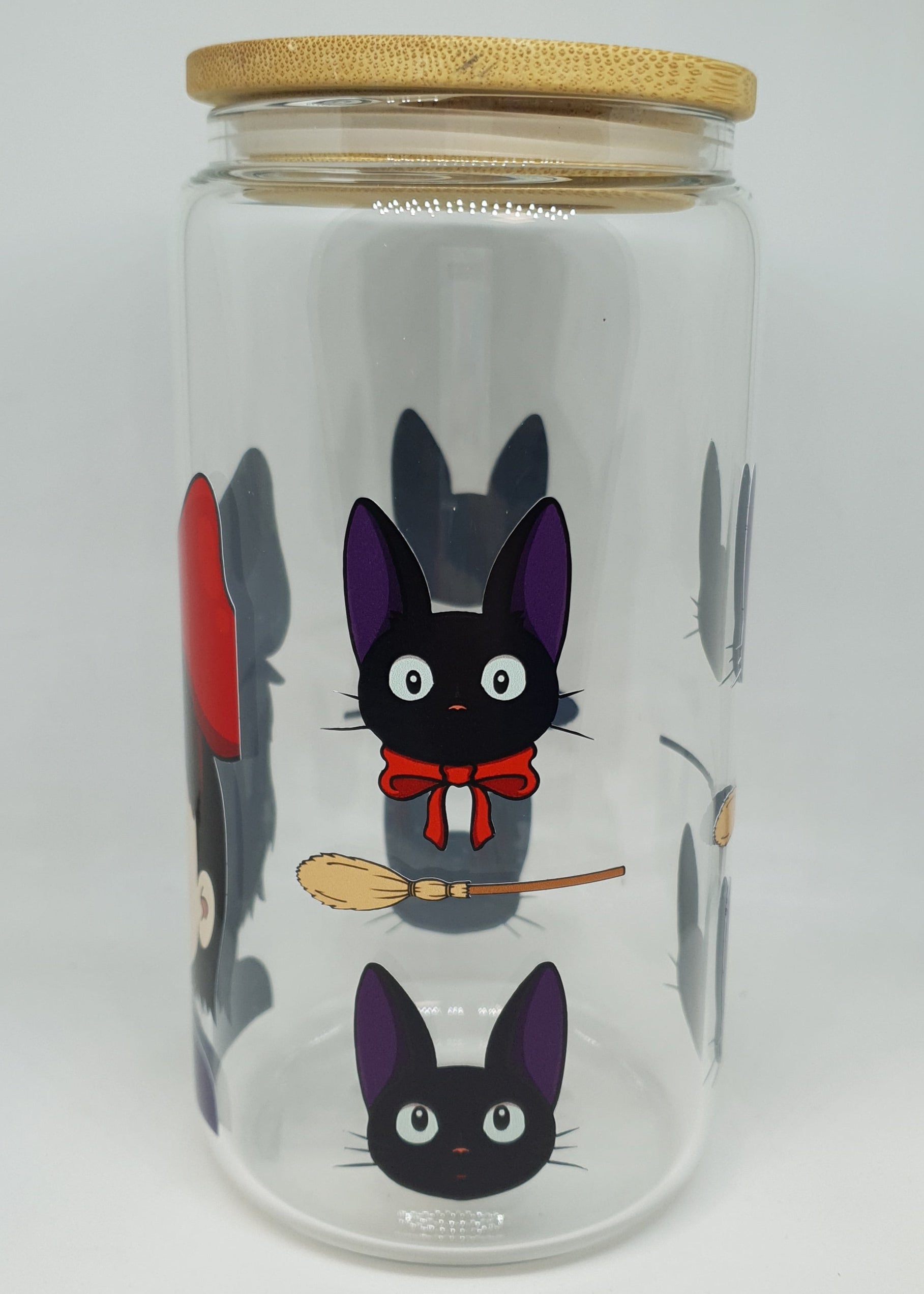 Clear glass jar with cartoon cat design and wooden lid on a white background