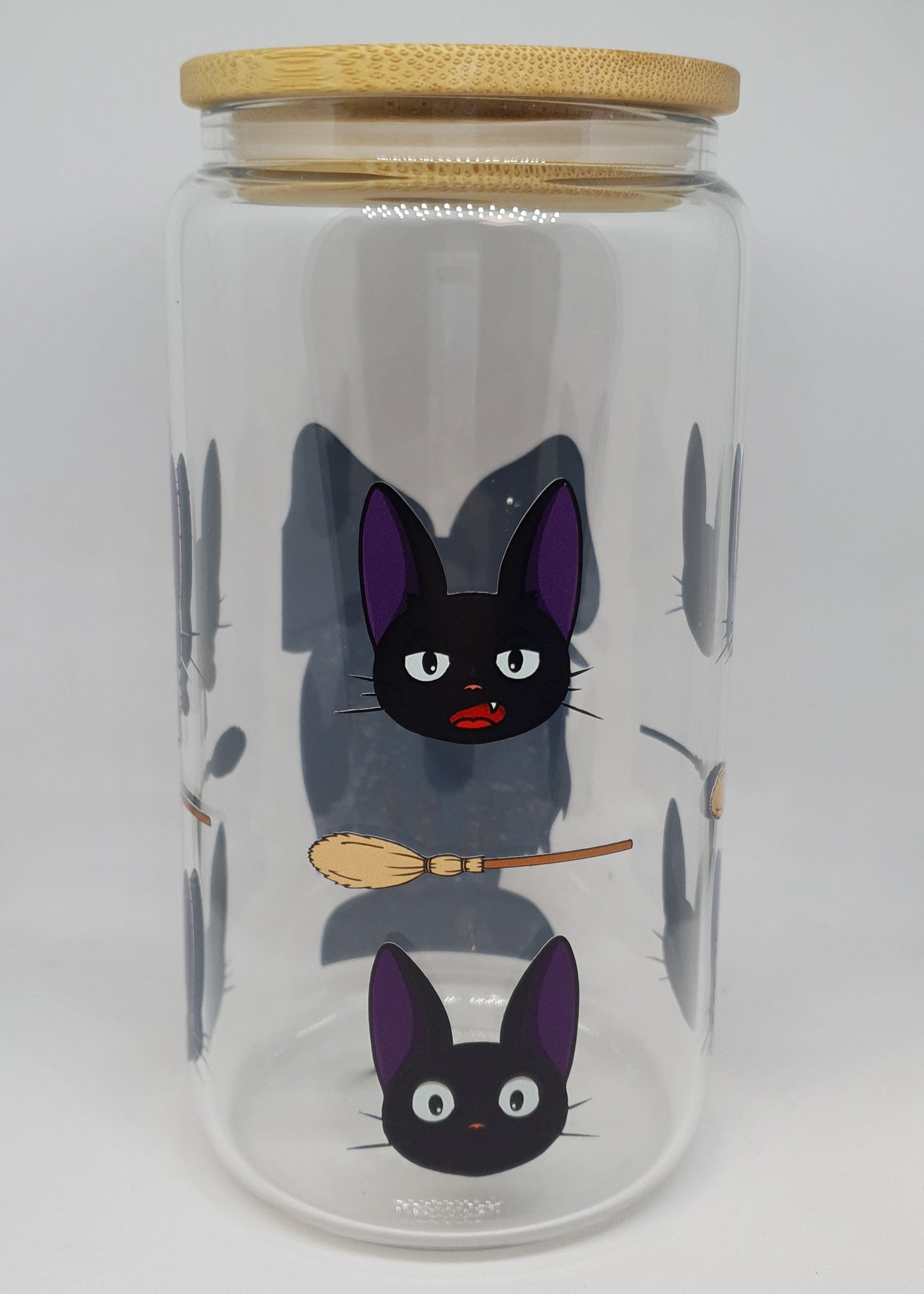Glass jar with cartoon cats and a broom on a white background