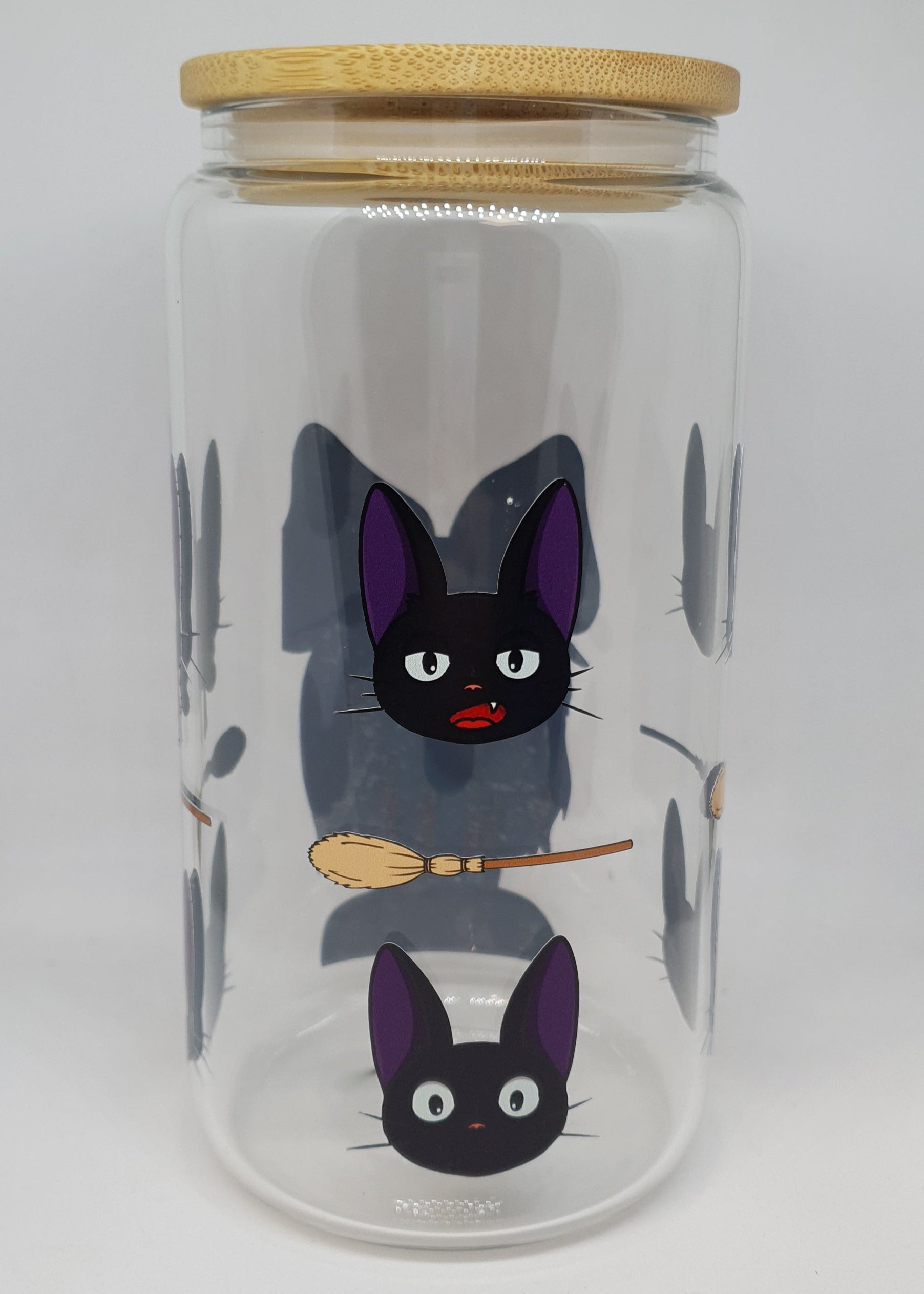 Glass jar with cartoon cats and a broom on a white background