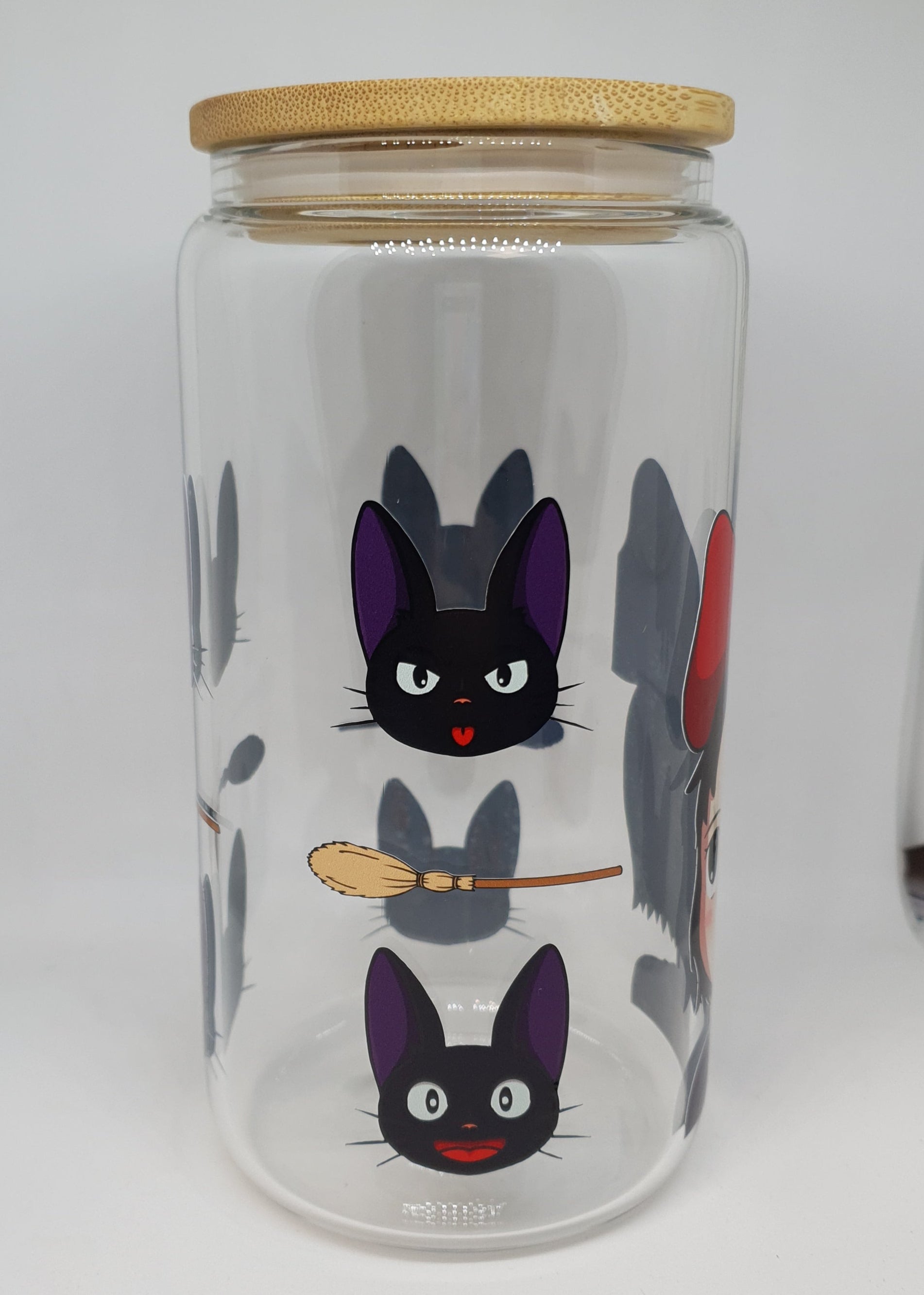 Clear glass bottle with cartoon cat design on a white background